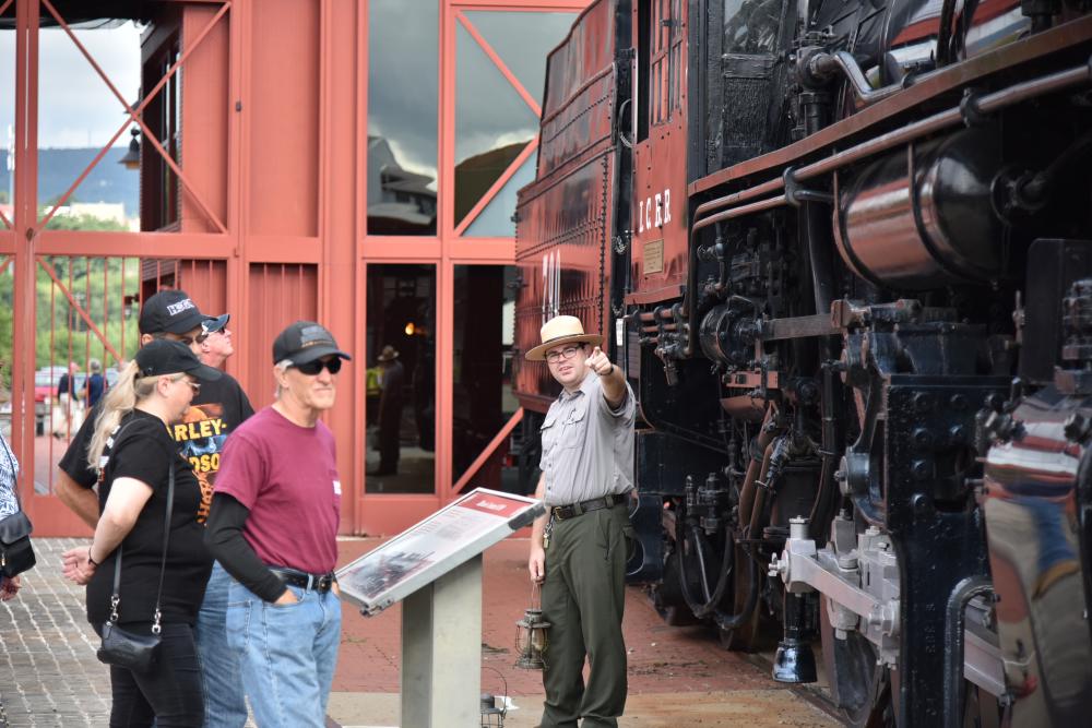 National Park Service Ranger speaking with guests in front of a locomotive at Steamtown National Historic Site in Scranton, PA
