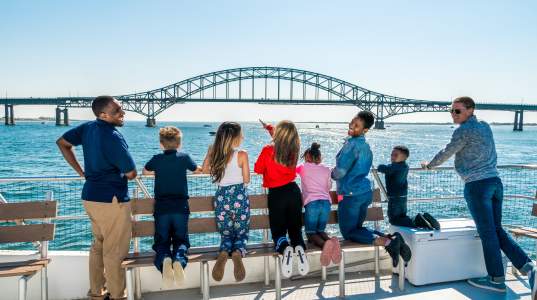 group of people on a boat looking out at the view of the ocean