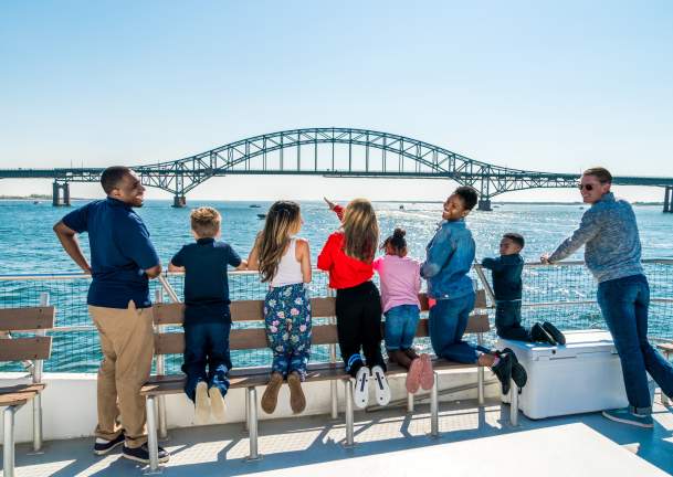 group of people on a boat looking out at the view of the ocean