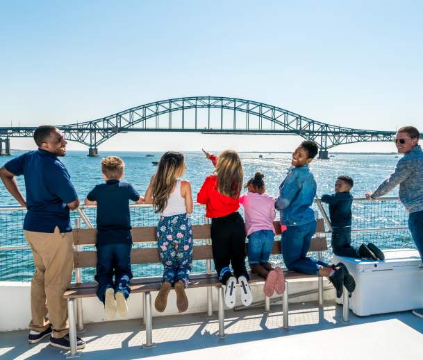 group of people on a boat looking out at the view of the ocean