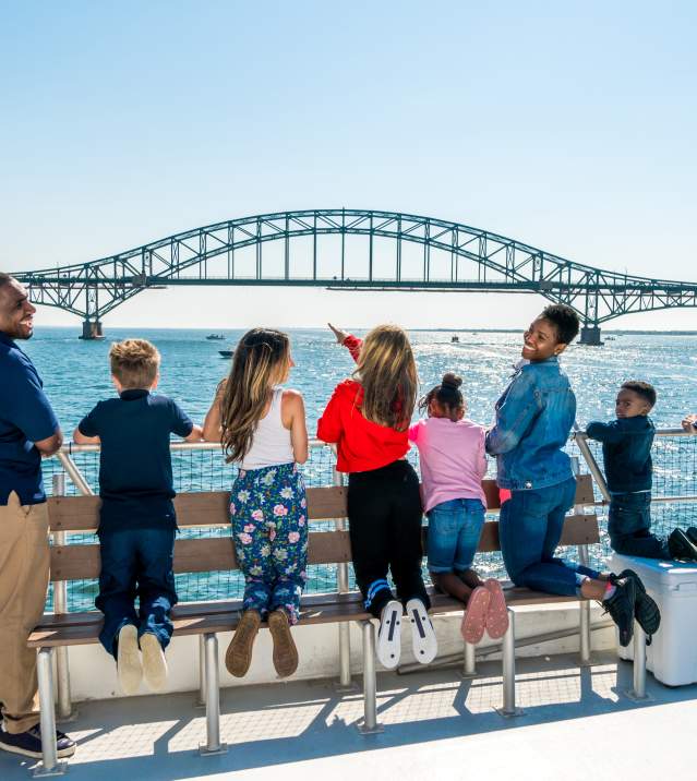 group of people on a boat looking out at the view of the ocean