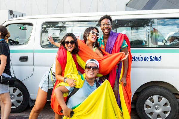 fotografía de asistentes a la marcha lgbt en los cabos cargando una bandera arcoíris