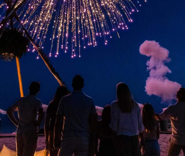 Family against a night sky watching fireworks