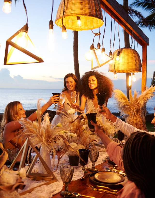 fotografía de una boda de mujeres lesbianas en la playa, brindando con amigos