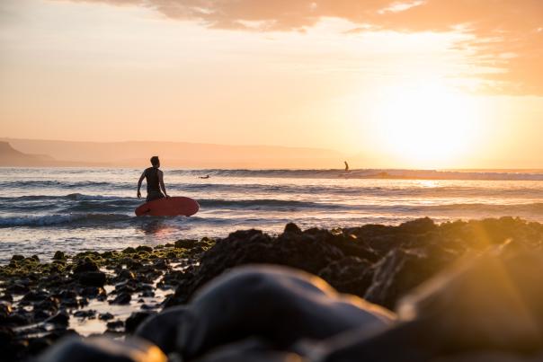 Surfista viendo el amanecer en playa de Los Cabos