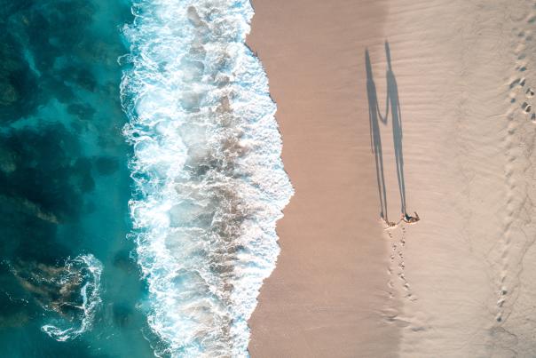 pareja caminando por la orilla de la playa