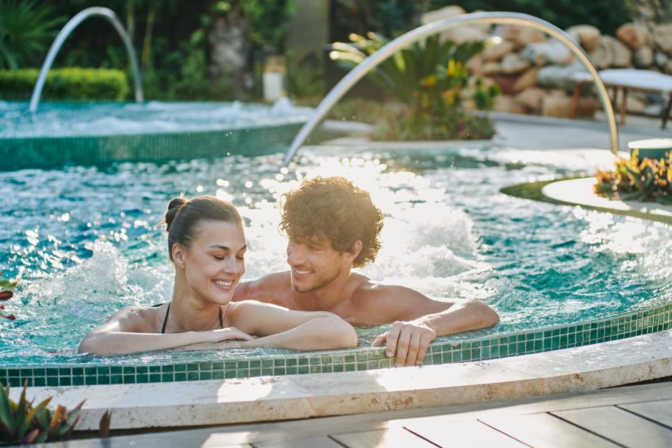 Pareja dentro de una alberca en hotel todo incluido en Los Cabos