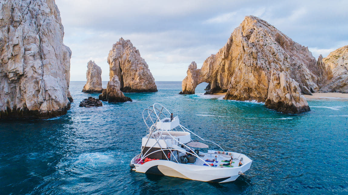 Vista panorámica del arco del cabo con el mar de cortés y un yate en medio