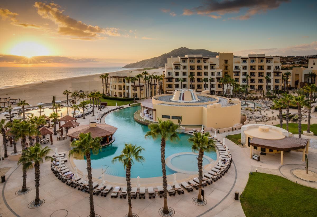 Pueblo Bonito Pacifica Golf & Spa Resort near pool with palm trees and a coastal view.