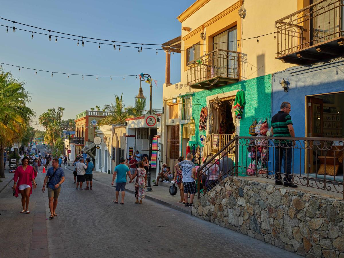 San Jose del Cabo street with colorful buildings, outdoor dining, local shops, and visitors walking through the historic Art District in Los Cabos.
