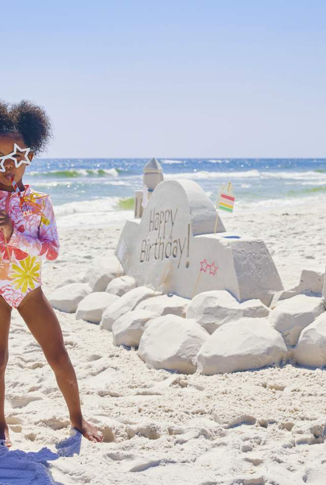 Kids celebrating happy birthday sandcastle