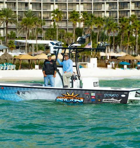 Two men posing for picture on a fishing boat with Panama City Beach in the background
