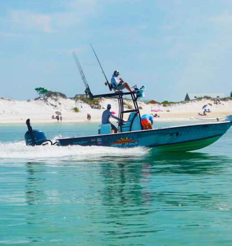 a boat sails near the beach