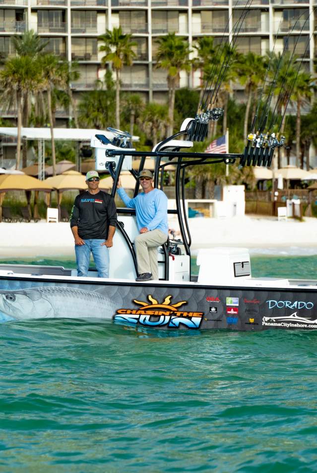 Two men posing for picture on a fishing boat with Panama City Beach in the background