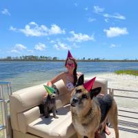 dog and woman on a boat at shell island in Panama City Beach