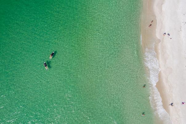 Aerial shot of paddle boarders along the coast of Panama City Beach