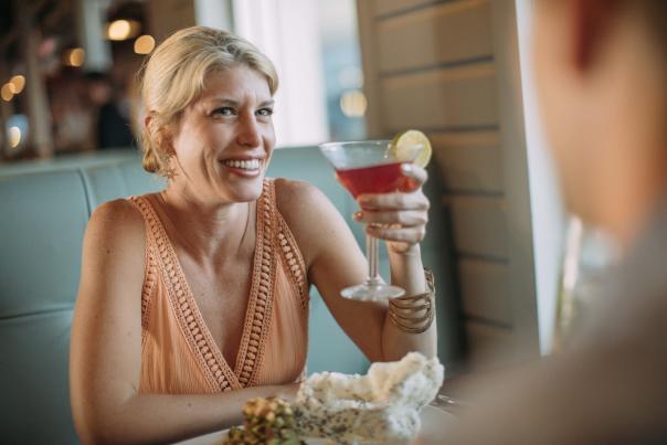 Women holding up a cocktail while sitting in a booth at a Mexican restaurant.
