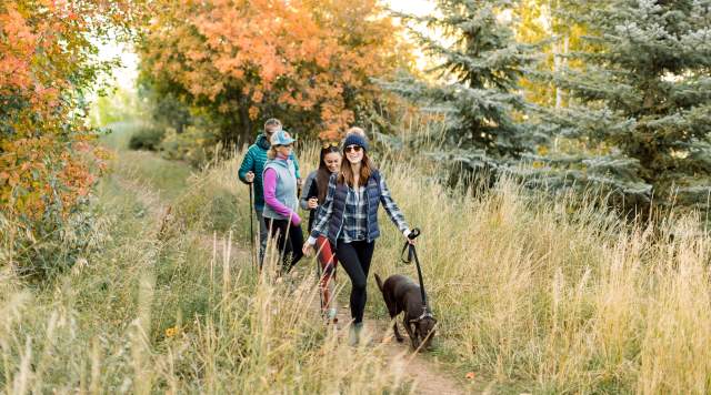 group of adults hiking with a dog on leash