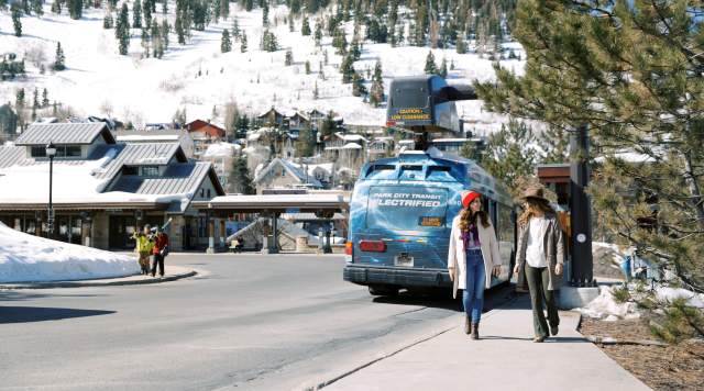 Girls walking past electric bus at Old Town transit Center