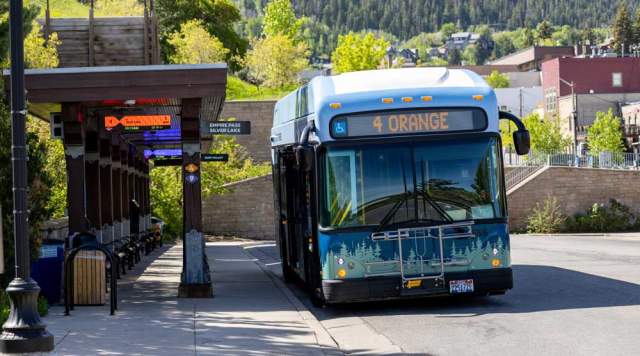 An electric city bus waits at the transit center on a sunny day in Park City, UT