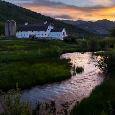 The McPolin Barn beyond a stream at sunset in Park City, UT