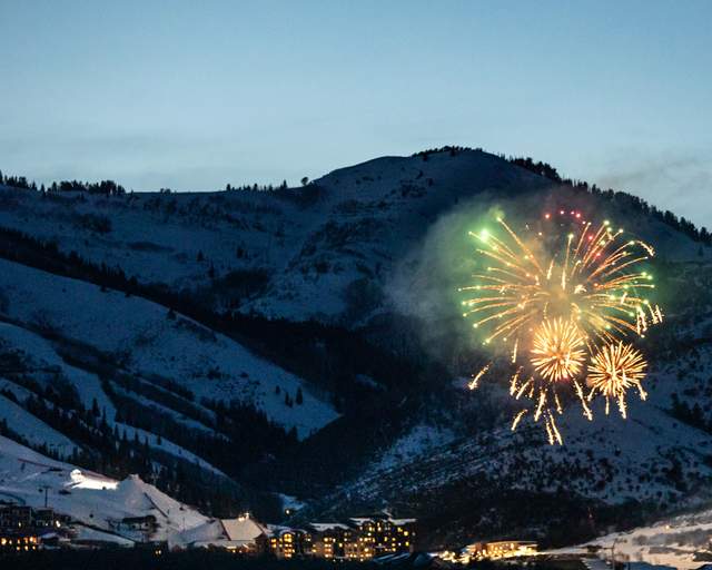 Fireworks explode over an event at dusk during the winter in Park City, UT