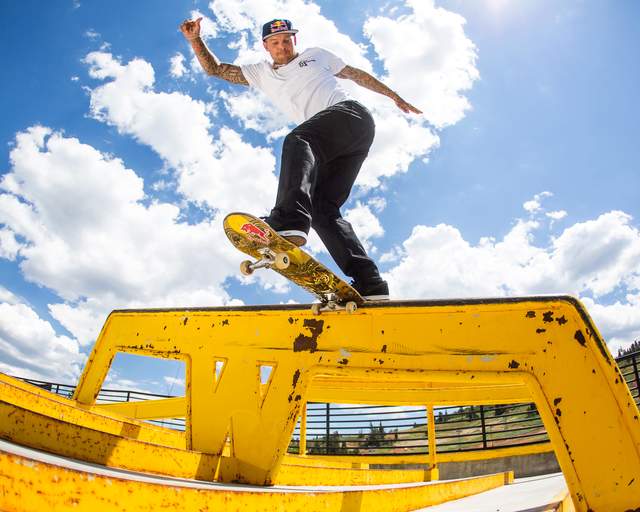 A skateboarder does a tail slide on a yellow rail at the Outside Park at Woodward in Park City, UT