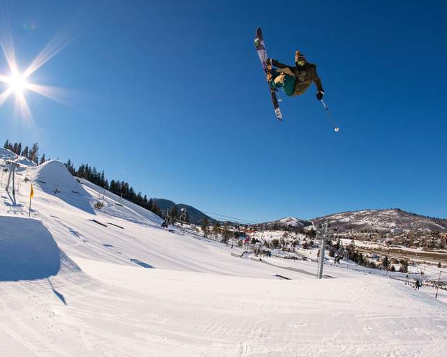 A skier does a trick through the air over a large jump at Woodward in Park City, UT