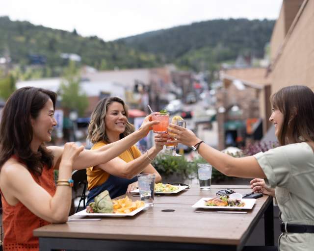 three women dining outside in summer
