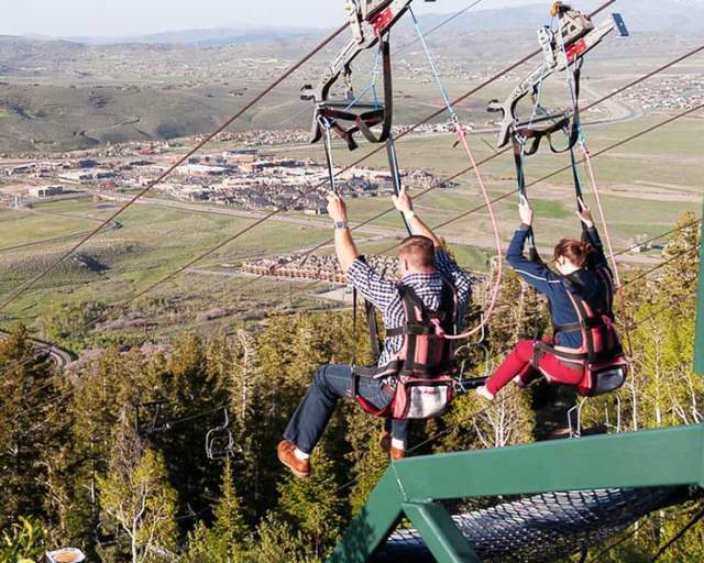 Couple at the top of the zip line at Utah Olympic Park in the summer