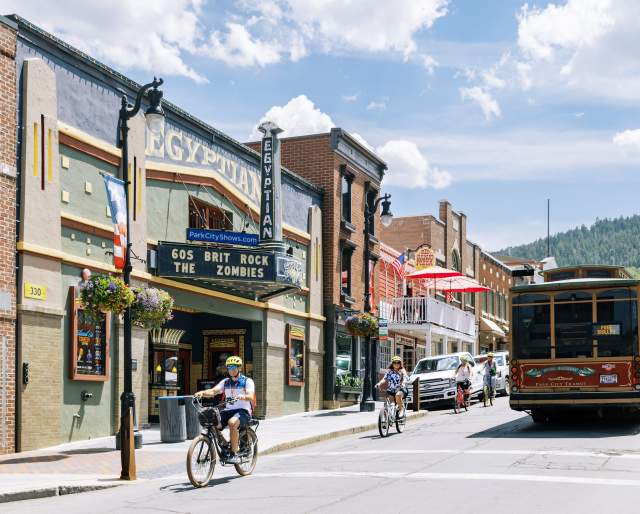 group riding bikes down main street passing the trolly