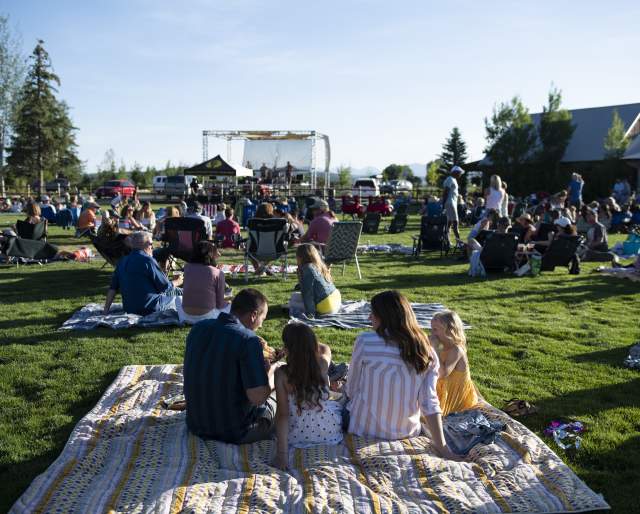 Family on picnic blanket during summer concert at High Star Ranch.