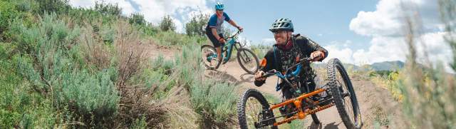 An adaptive mountain biker rides on a wide trail in Round Valley in Park City, UT