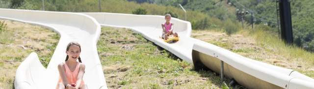 Two people enjoying the alpine slide at park city mountain