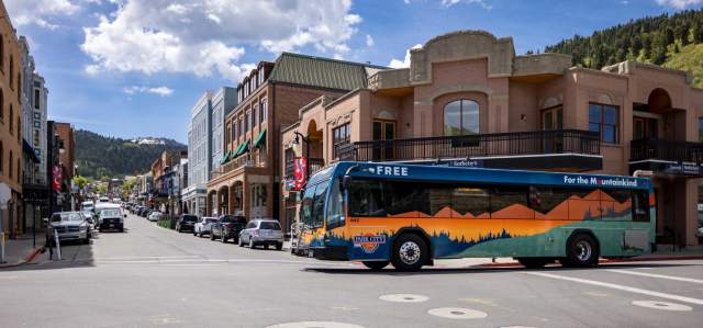 A city bus crosses Main Street on a sunny day in Park City, UT