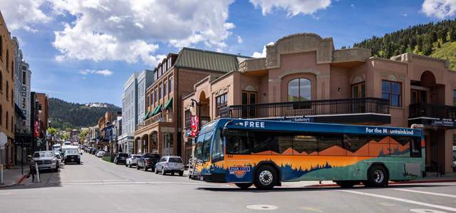 A city bus crosses Main Street on a sunny day in Park City, UT