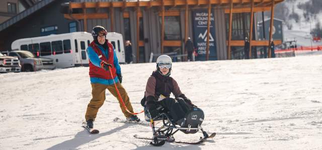 A guide and adaptive athlete on a ski run at Park City Mountain in Park City, UT