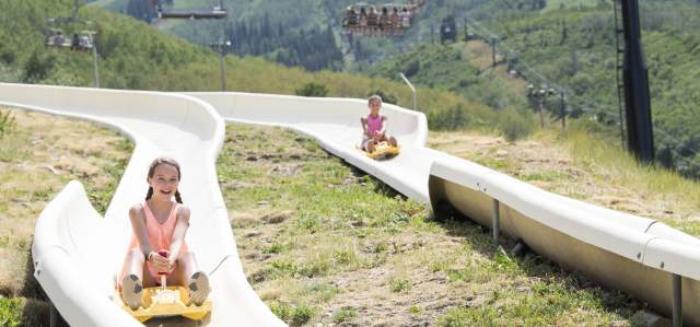 Two people enjoying the alpine slide at park city mountain