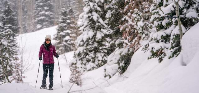 A snowshoer hikes through a wooded area near Park City, UT