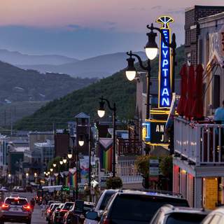 Patrons eat on a restaurant deck overlooking Main Street, Park City, UT at dusk.