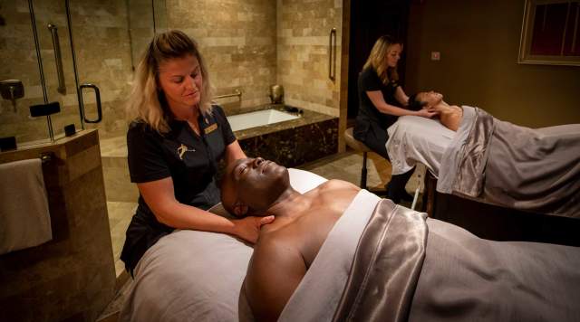 A couple receives a massage in a soft lit spa in Park City, UT