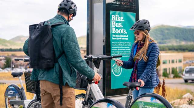Two people check out e-bikes using an app in Park City,  UT