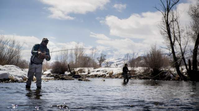 Two people fly fishing in the winter