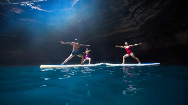 Three women doing yoga on stand up paddleboards in a crater near Park City, UT