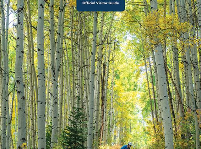 Cover of the official Park City Visitor's Guest Guide with a mountain biker riding through a forest in the fall.