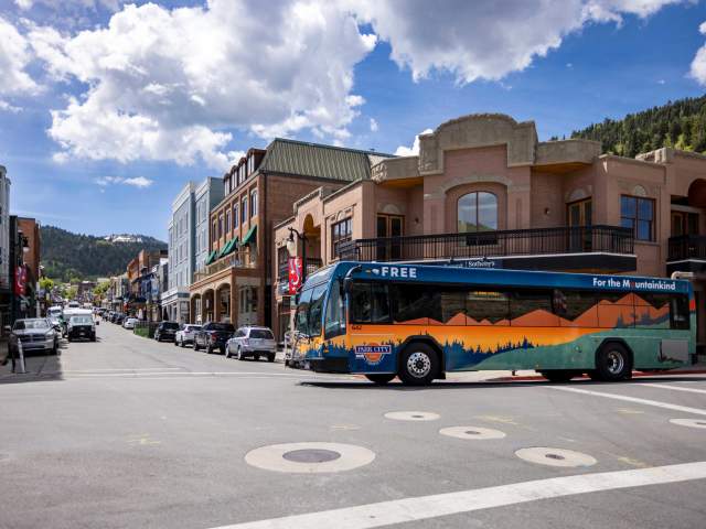 A city bus crosses Main Street on a sunny day in Park City, UT