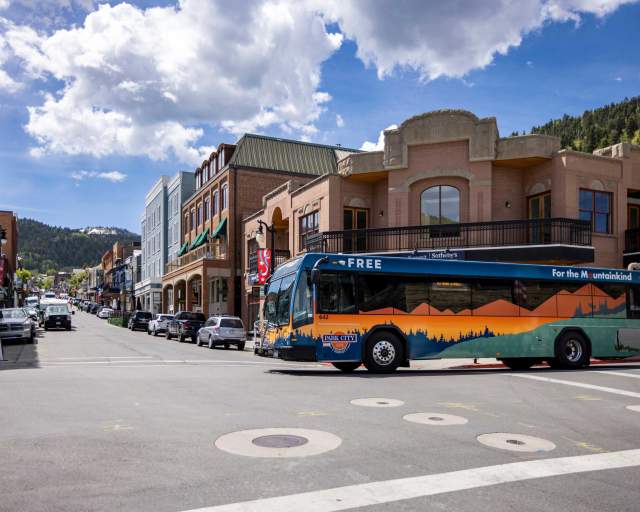A city bus crosses Main Street on a sunny day in Park City, UT