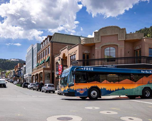 A city bus crosses Main Street on a sunny day in Park City, UT