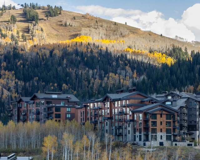A hotel tucked into a hillside and surrounded by forest in the fall in Park City, UT