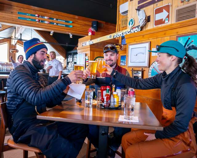 Three skiers enjoy apres ski drinks at the Sticky Wicket bar at Deer Valley Resort in Park City, UT